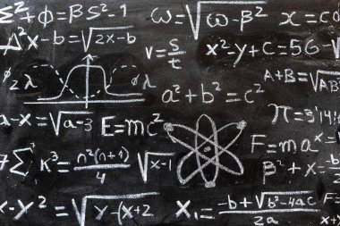 Matematiksel ve kuantum fiziği işlemleri ve formülleri tahtaya tebeşirle yazılmış.