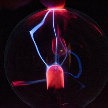 Siyah zemin üzerinde mor-mavi parlayan bir plazma topunun içindeki elektromanyetik ışınlar