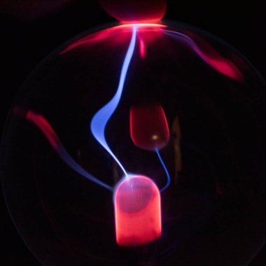 Siyah zemin üzerinde mor-mavi parlayan bir plazma topunun içindeki elektromanyetik ışınlar