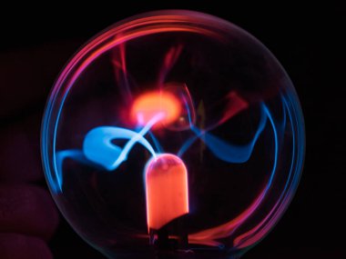 Siyah zemin üzerinde mor-mavi parlayan bir plazma topunun içindeki elektromanyetik ışınlar