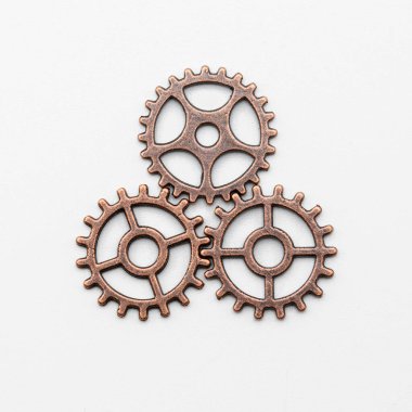 Bakırdan metal dişli tekerlekler ve farklı boyutlarda bronzdan, beyaz üzerinde izole edilmiş.