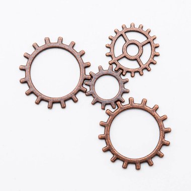 Bakırdan metal dişli tekerlekler ve farklı boyutlarda bronzdan, beyaz üzerinde izole edilmiş.