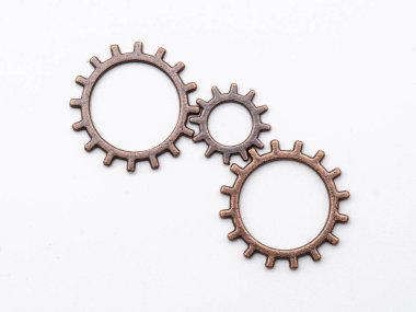 Bakırdan metal dişli tekerlekler ve farklı boyutlarda bronzdan, beyaz üzerinde izole edilmiş.