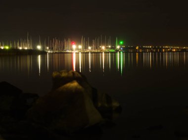 Balaton Gölü yat limanının gece görüşü demirli teknelerle, ışıkları sakin suyu yansıtıyor..