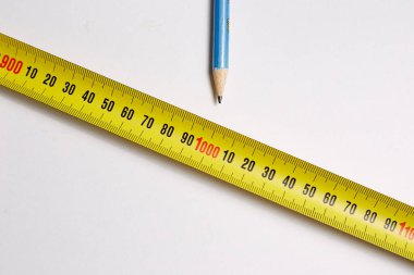 İnşaat işi için beyaz arkaplanda kurşun kalemle mezuranın ölçülmesi gerekiyor.