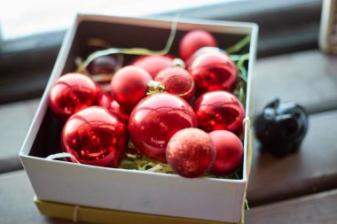 Kırmızı Noel topları pencerenin yanındaki bir kutuda. Tatil kavramı.