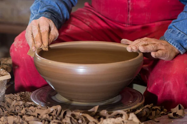 potter\'s hands working with clay on potter\'s wheel, forming bowl. Traditional pottery, craft handicrafts, authentic atmosphere