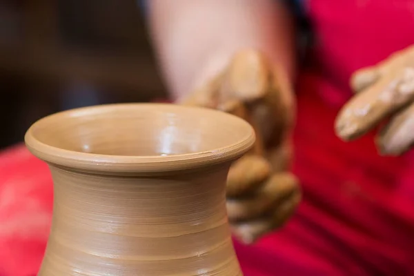 potter\'s hands working with clay on potter\'s wheel, forming bowl. Traditional pottery, craft handicrafts, authentic atmosphere