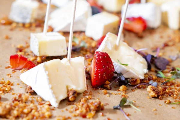 Cheese platter with organic cheeses - blue cheese cheddar, emmantaler, french soft cheese with strong smell, italian parmesan, grapes, tomatoes, olives, nuts and strawberries