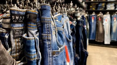 Bir Giyim Mağazasında, Denim Moda, Alışveriş ve Perakende Konsepti 'nde, Bir Rafta Giysi Askısı, Alışveriş, Moda ve Perakende Konsepti' nde kot pantolonlar sergilendi. Kaliteli fotoğraf. Kauno, Kauno m. SAv., Litvanya 04.27.2025
