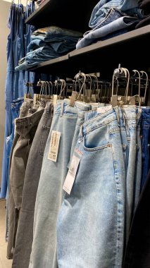 Bir Giyim Mağazasında, Denim Moda, Alışveriş ve Perakende Konsepti 'nde, Bir Rafta Giysi Askısı, Alışveriş, Moda ve Perakende Konsepti' nde kot pantolonlar sergilendi. Kaliteli fotoğraf. Kauno, Kauno m. SAv., Litvanya 04.27.2025