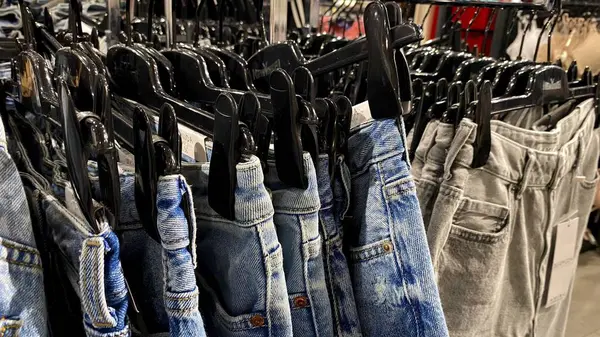 Bir Giyim Mağazasında, Denim Moda, Alışveriş ve Perakende Konsepti 'nde, Bir Rafta Giysi Askısı, Alışveriş, Moda ve Perakende Konsepti' nde kot pantolonlar sergilendi. Kaliteli fotoğraf. Kauno, Kauno m. SAv., Litvanya 04.27.2025