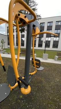 Açık hava jimnastik makinesi bir konut avlusuna kurulmuş. Göğüs ütüsü ve iniş istasyonunu birleştiriyor. Çocuk parkının yanında yer alan bu ekipman, yetişkinler ve şehir ortamlarındaki gençler için fiziksel aktiviteyi teşvik etmektedir. Bunun için uygun.