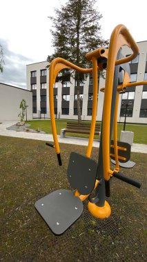 Açık hava jimnastik makinesi bir konut avlusuna kurulmuş. Göğüs ütüsü ve iniş istasyonunu birleştiriyor. Çocuk parkının yanında yer alan bu ekipman, yetişkinler ve şehir ortamlarındaki gençler için fiziksel aktiviteyi teşvik etmektedir. Bunun için uygun.