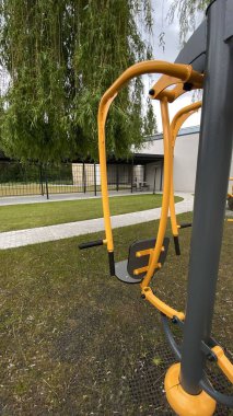 Açık hava jimnastik makinesi bir konut avlusuna kurulmuş. Göğüs ütüsü ve iniş istasyonunu birleştiriyor. Çocuk parkının yanında yer alan bu ekipman, yetişkinler ve şehir ortamlarındaki gençler için fiziksel aktiviteyi teşvik etmektedir. Bunun için uygun.