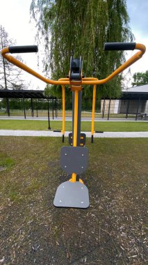 Açık hava jimnastik makinesi bir konut avlusuna kurulmuş. Göğüs ütüsü ve iniş istasyonunu birleştiriyor. Çocuk parkının yanında yer alan bu ekipman, yetişkinler ve şehir ortamlarındaki gençler için fiziksel aktiviteyi teşvik etmektedir. Bunun için uygun.