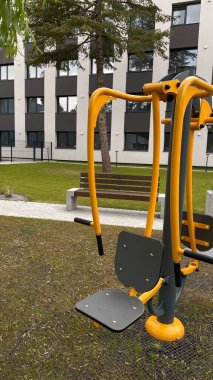Açık hava jimnastik makinesi bir konut avlusuna kurulmuş. Göğüs ütüsü ve iniş istasyonunu birleştiriyor. Çocuk parkının yanında yer alan bu ekipman, yetişkinler ve şehir ortamlarındaki gençler için fiziksel aktiviteyi teşvik etmektedir. Bunun için uygun.