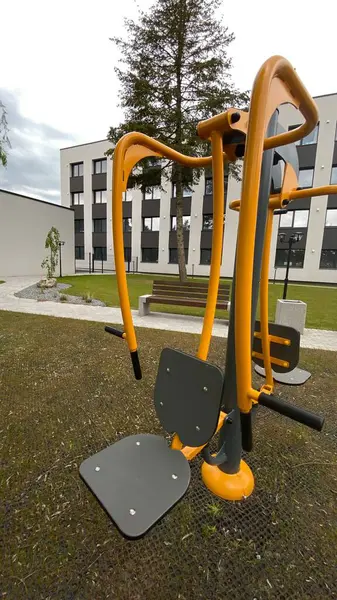 Açık hava jimnastik makinesi bir konut avlusuna kurulmuş. Göğüs ütüsü ve iniş istasyonunu birleştiriyor. Çocuk parkının yanında yer alan bu ekipman, yetişkinler ve şehir ortamlarındaki gençler için fiziksel aktiviteyi teşvik etmektedir. Bunun için uygun.