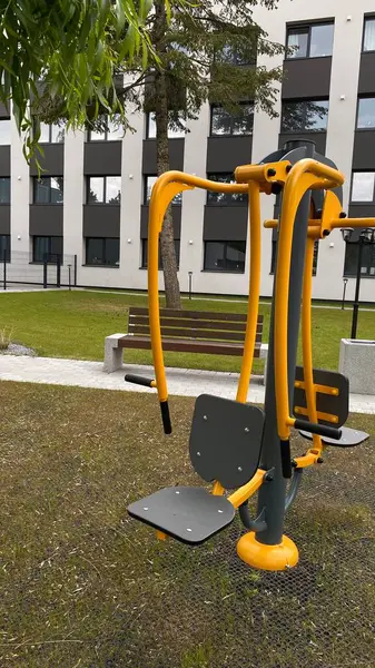 Açık hava jimnastik makinesi bir konut avlusuna kurulmuş. Göğüs ütüsü ve iniş istasyonunu birleştiriyor. Çocuk parkının yanında yer alan bu ekipman, yetişkinler ve şehir ortamlarındaki gençler için fiziksel aktiviteyi teşvik etmektedir. Bunun için uygun.