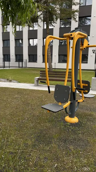 Açık hava jimnastik makinesi bir konut avlusuna kurulmuş. Göğüs ütüsü ve iniş istasyonunu birleştiriyor. Çocuk parkının yanında yer alan bu ekipman, yetişkinler ve şehir ortamlarındaki gençler için fiziksel aktiviteyi teşvik etmektedir. Bunun için uygun.