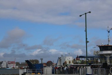 Litvanya, Klaipeda 'da nehir feribotuna binen bir grup insan. Sakin su, yaz atmosferi, şehir geçmişi ve Baltık şehrinde günlük yaşam sahneleri. Ulaşım, şehir hayatı, seyahat ve turizm konuları için mükemmel.