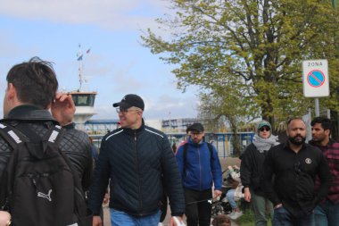 Litvanya, Klaipeda 'da nehir feribotuna binen bir grup insan. Sakin su, yaz atmosferi, şehir geçmişi ve Baltık şehrinde günlük yaşam sahneleri. Ulaşım, şehir hayatı, seyahat ve turizm konuları için mükemmel.