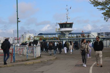 Litvanya, Klaipeda 'da nehir feribotuna binen bir grup insan. Sakin su, yaz atmosferi, şehir geçmişi ve Baltık şehrinde günlük yaşam sahneleri. Ulaşım, şehir hayatı, seyahat ve turizm konuları için mükemmel.