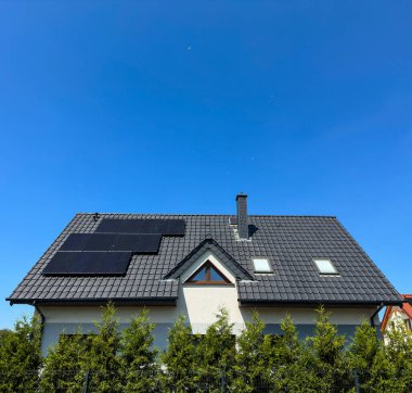 Güneş panelleri ve mavi gökyüzü kopya alanı olan modern bir özel evin çatısı. Fotovoltaikler soyut.