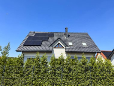 Güneş panelleri ve mavi gökyüzü kopya alanı olan modern bir özel evin çatısı. Fotovoltaikler soyut.