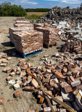 Eski kırmızı tuğlaların geri dönüşümü. Beton döküntüleri ve tuğlalar satılmaya hazır. Yeniden kullanılabilir yapı malzemeleri soyut.