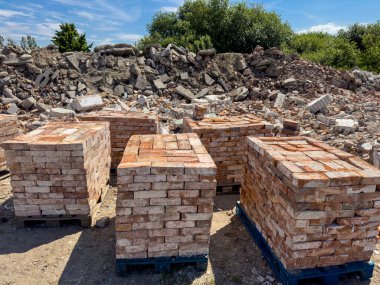Eski kırmızı tuğlaların geri dönüşümü. Beton döküntüleri ve tuğlalar satılmaya hazır. Yeniden kullanılabilir yapı malzemeleri soyut.