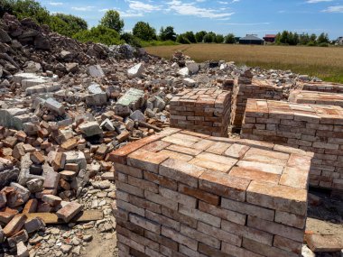 Eski kırmızı tuğlaların geri dönüşümü. Beton döküntüleri ve tuğlalar satılmaya hazır. Yeniden kullanılabilir yapı malzemeleri soyut.
