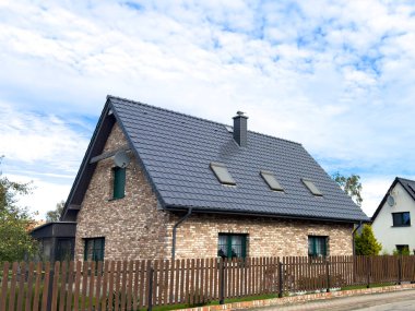 Polonya 'da tek kişilik şık bir aile evi. Sokaktan, çitten ve çatıdan ana özellikler olarak görülüyor. Hollanda stili dış cepheye tuğla atıyor.