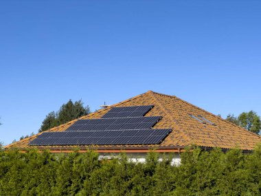 Güneş panelleri olan özel bir evin çatısı. Boşluk olarak açık mavi gökyüzü.