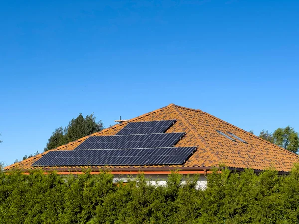 Güneş panelleri olan özel bir evin çatısı. Boşluk olarak açık mavi gökyüzü.