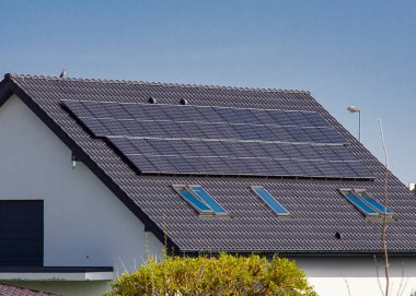 Roof of a private house in Europe with solar panels. Real estate with renewable energy source eco solar panels concept. clipart