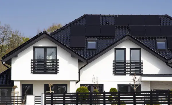 stock image Roof of a private house in Europe with solar panels. Real estate with renewable energy source eco solar panels concept.