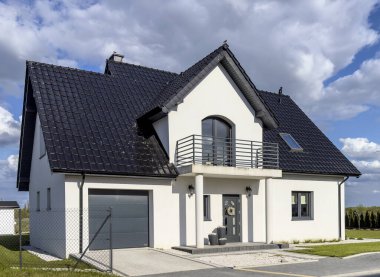 Tek aile evi Avrupa tarzı, modern mimari. Zarif bir gayrimenkul, cephe manzarası. Siyah çatılar ve beyaz duvarlar..