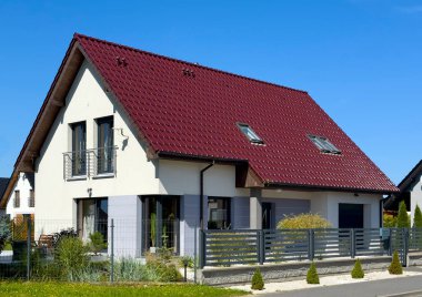 Polonya 'da kırmızı kiremit çatılı ve grafit çitli modern bekar aile evi. Çağdaş mimari soyut.
