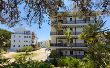 Portekiz 'in Olhos de Agua şehrinin modern mimarisi. Yeşil yemyeşil bitki örtüsüyle çevrili zarif apartmanlar..