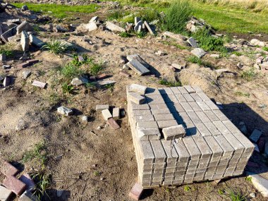 Enkazdan çıkan tuğlaları geri dönüştürüyorum. Yeniden kullanılabilir yapı malzemeleri soyut. Yeniden düzenleme öbeklerinden tuğla toplanıyor.