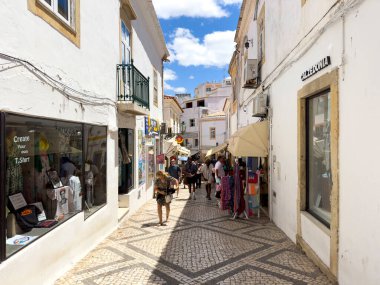 Albufeira, Portugal, June 26th 2024 - the city centre narrow street with tourists walking among the local shops. clipart