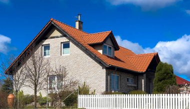 Tuğla kaplamalı ve beyaz çitli zarif bir banliyö evi. Çağdaş Polonya mimarisi.