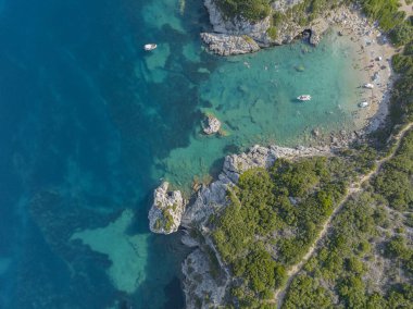 Yunanistan 'ın Korfu adasındaki Porto Timoni plajına giden kıyı şeridinin havadan görüntüsü. Kristal berrak sularla yıkanmış iki kumsal oluşturan ince bir şerit..