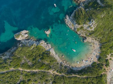 Yunanistan 'ın Korfu adasındaki Porto Timoni plajına giden kıyı şeridinin havadan görüntüsü. Kristal berrak sularla yıkanmış iki kumsal oluşturan ince bir şerit..