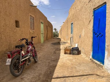Sahara Desert, Morocco, Africa, 19-03-2023: a motorbike in an alley and blue sky with clouds in Merzouga, departure city for tourists visiting the sandy desert and the Erg Chebbi dunes