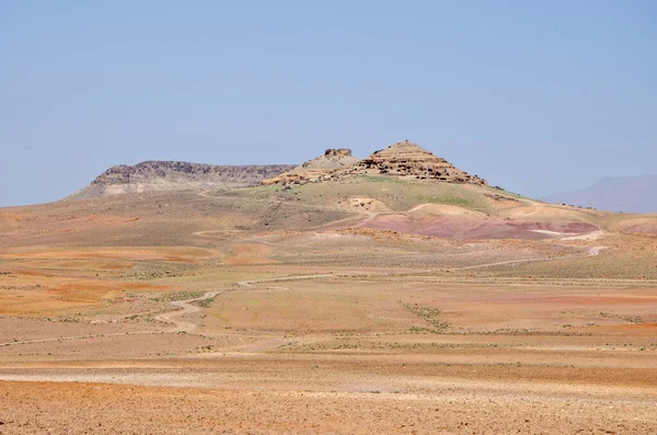 Desert landscapes in Morocco, desolate lands with paths that lead to remote and unexplored corners. Climate change and arid climate. Desertification and lack of water. Mountains and hills on the horizon