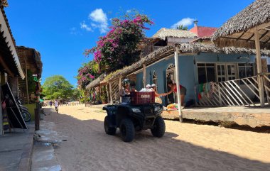 Brezilya, 15-06-2023: Jericoacoara 'da kum arabası süren bir kadın, Güney Amerika' nın kuzeydoğusunda kum sokakları olan ünlü şehir.
