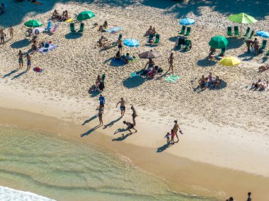 Ipanema plajının havadan görünüşü. İnsanlar sahilde güneşleniyor, oyun oynuyor, deniz sporları yapıyorlar. Rio de Janeiro 'da. Brezilya