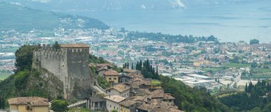 Ortaçağ duvarları ve Riva del Garda 'ya tepeden bakan Tenno kalesinin havadan görünüşü. Garda Gölü 'nün etrafındaki dağlar ve tepeler. Trentino, İtalya